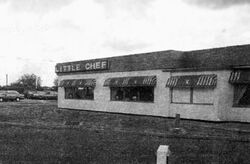 Black and white image of restaurant building with a flat roof and a sign saying Little Chef.
