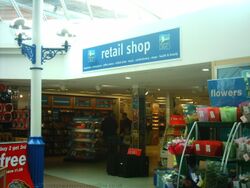 A sign saying retail shop, above the entrance to a service area newsagent.