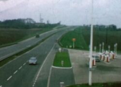 A dual carriageway, with a blurry view of a petrol station on the left.