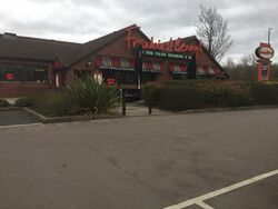Brick building with a two pitched roof, and a sign saying Frankie & Benny's.