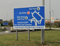 A complicated roundabout sign with lots of symbols and exits.