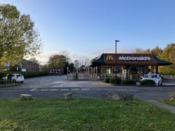A McDonald's restaurant behind a grass lawn and car park.