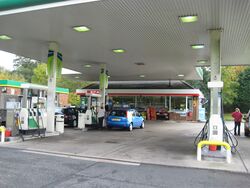 View inside a petrol station with a SPAR-branded shop in the distance.