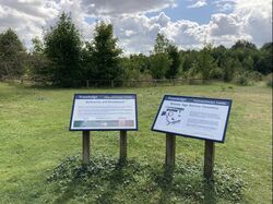 Two information boards in a field, with the Travelodge logo on them.
