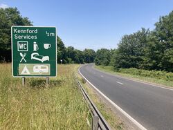 Green road sign saying Kennford services.