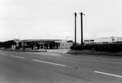 Black and white photo of an Esso filling station and Little Chef restaurant.