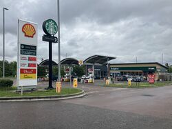The logos for Shell and Starbucks, in front of a forecourt with a very small canopy.