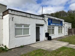 An old, single-storey building with a sign saying: Shower and Toilets.