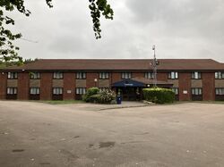 A two-storey, brick building with a 'Travelodge' sign over the door.
