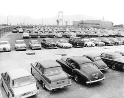 Black and white photo showing old cars parked outside the service area.