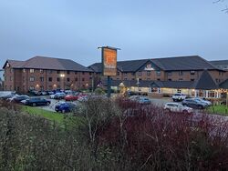 A three-storey brick building, surrounding a car park.