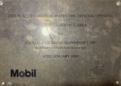 A plaque reading: This plaque commemorates the official opening of Warwick service area by The Rt Hon Dr Brian Mawhinney MP, Secretary of State for Transport, 18th January 1995, with the logos of Mobil and Welcome Break.