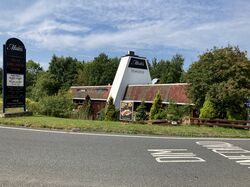 A restaurant with a tall, white chimney, with a sign saying Maahis.