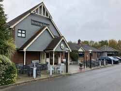 A modern pub building with a tall roof and a sign saying Bowling Green.