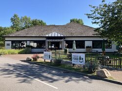 White building with the words Hog and Hedge written over the door.