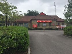 A restaurant building at the end of a driveway, with a sign saying Little Chef.