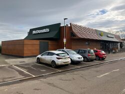 A McDonald's restaurant, with cars parked in front.