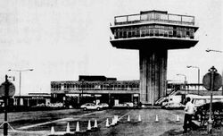 Black and white picture of the front of the building, showing the tower on the right.