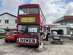 A red double decker bus which says Eat On The Bus.
