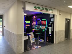 A sign saying Amusements, in a green font with a red stripe, above a game arcade.